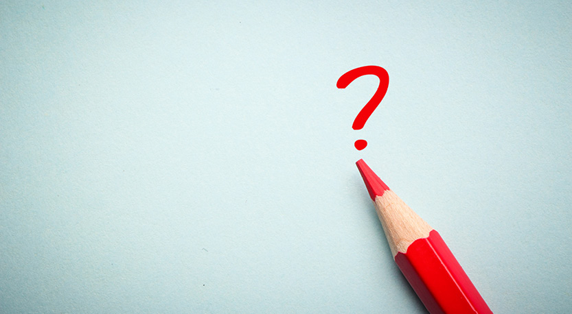 red pencil on blue paper with a question mark written on it