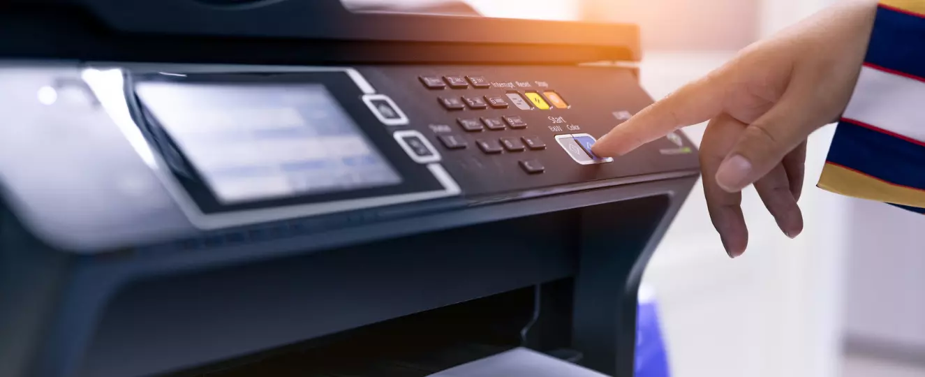 Office worker printing paper on multifunction laser printer.