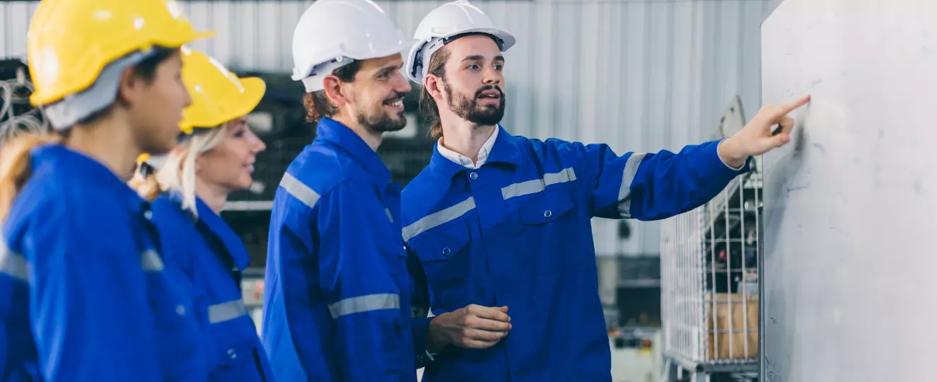 Group of people in safety gear pointing at a board